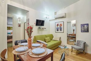 Salon avec canapé, TV, espace repas pour 4 personnes