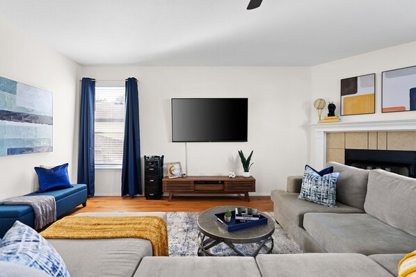 Cozy living room with a plush sectional, smart TV, and chic décor. Near Dell Diamond, Kalahari, and Round Rock Donuts—perfect for relaxing!