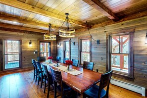 Gather around the large rustic table, crafted from solid wood with a warm, weathered finish — perfect for family meals, game nights, or sharing stories after a day of adventure.