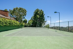 The lighted tennis court includes a basketball hoop