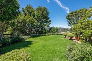 The large grassy lawn is great for sports and overlooks the tennis court and Bal Air canyon