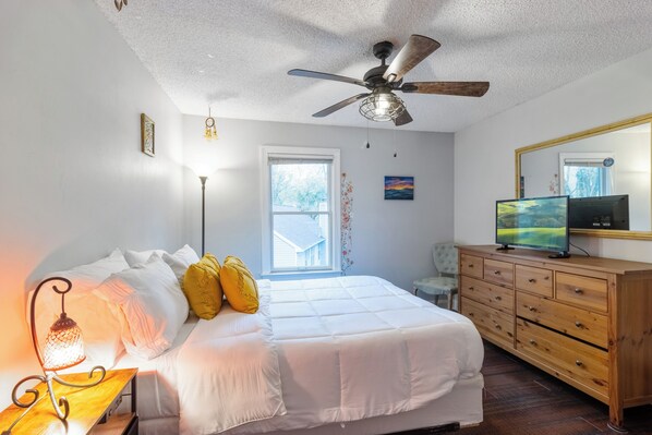 Cozy queen bedroom with plush bedding, natural light, and ample closet space.