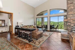 2nd Floor: Main living area featuring designer furnishings, access to the 1st private balcony, and a beautiful view of Prescott's natural scenery.