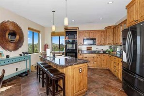 2nd Floor: The main kitchen is fully equipped with stainless steal appliances and a kitchen island with bar seating for 4 guests.
