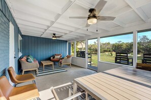 Spacious screened-in patio with comfortable seating, ceiling fans, and a dining area—perfect for relaxing and enjoying the outdoors in any weather.





