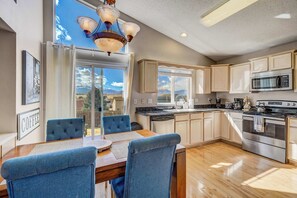 This bright and open kitchen features modern appliances, ample counter space, and a dining area with stunning views for a perfect mealtime experience.

