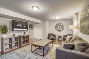 The lower-level entertainment space includes a large Smart TV, cozy seating, and stylish decor, making it perfect for movie nights or relaxing after a day of adventure.

