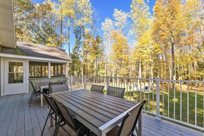 Sprawling Scott Creek Lodge back deck with dining seating (NO gas grill) overlooking the back yard & woods beyond; accessed via both the living room & screened porch