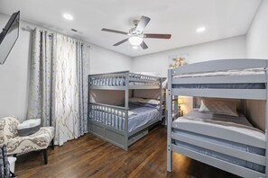 A bunk bed haven! Two twin and two double beds with a flat-screen TV—great for kids, friends, or a group stay.