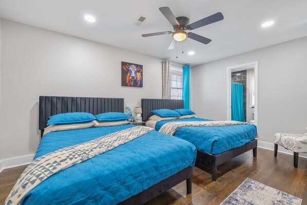 Pure luxury! Two queen beds with plush headboards, a ceiling fan, a large flat-screen TV, and a private ensuite bathroom—your personal retreat.