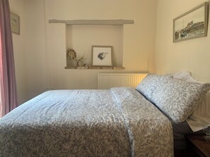 The bedroom with French doors looking out to the riverside terrace . 