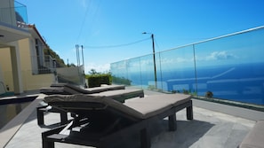 Elegant sun loungers positioned for ultimate relaxation, overlooking the stunning ocean view. A serene spot to soak up the sun and enjoy the breathtaking surroundings #sunbathing