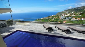Pool surrounded by sun loungers, offering panoramic ocean and mountain views, with Arco da Calheta village as a picturesque backdrop. A true haven of tranquility and beauty #holidays #calheta #pool