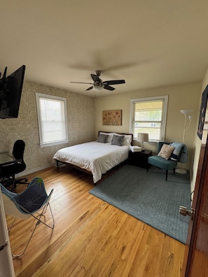 Cozy room with queen bed, desk, ceiling fan and plenty of natural light.
