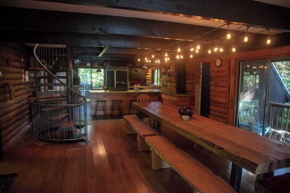 Main Lodge Dining table and kitchen with spiral staircase.
