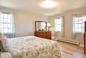 King sized bed located on the first floor with AC and charging cables.