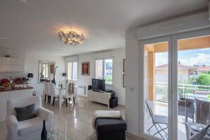 Living room and kitchen, entrance to sunny balcony