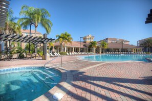 Relax in the stunning resort's shared pool surrounded by palm trees and sunshine.