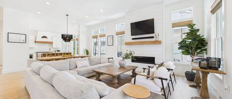 Open concept living area with stylish furnishings and huge TV