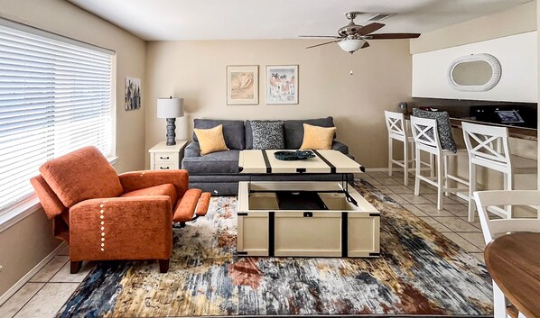 Living Room Features Recliner and Coffee Table that Opens toward couch