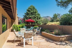 Beautifully landscaped courtyard with outdoor dining and sun loungers.