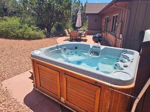 Relax in the outdoor hot tub, nestled in the backyard patio.