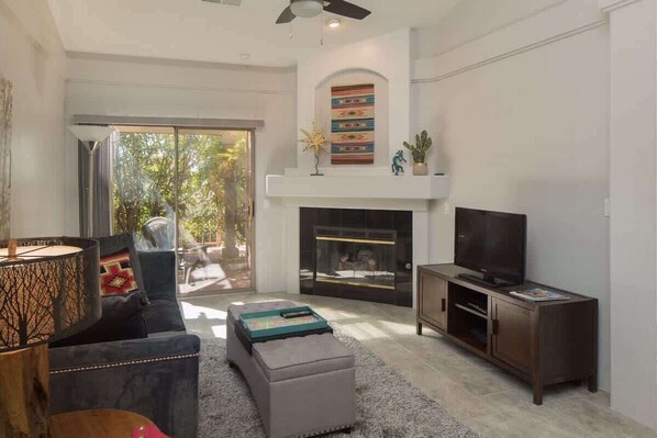 Spacious living room with TV and overhead fan 