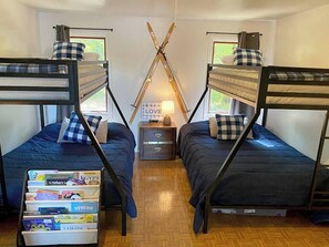Bunk room includes two bunk beds with full beds on bottom bunk. This room also has a TV for movies and a cozy couch.