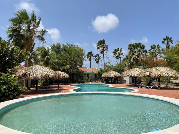 Community pool with cabanas and loungers.
