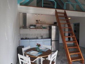 Kitchen with full sized refrigerator, cooktop, and toaster oven.