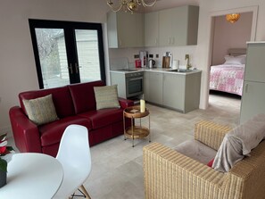 Open plan living, dining & kitchen leading into bedroom. View down to the lake.