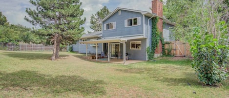 This spacious backyard features a covered patio, mature trees, and plenty of open space to relax and enjoy the outdoors. A perfect setting for gatherings or quiet moments in nature.