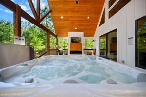 Private hot tub on spacious deck with outdoor seating, fireplace, and TV