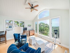 This charming sitting area with elegant furnishings overlooks the vibrant landscape, creating a perfect spot for enjoying scenic views and peaceful moments.