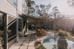 North facing alfresco dinning with outdoor fireplace and sun/rain awning. 