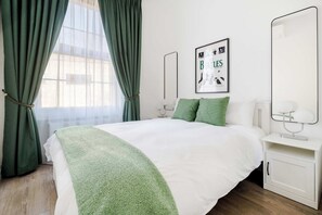 Bedroom 1: Ensuite with king bed, A/C & private bath for a restful stay.