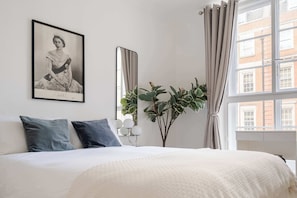 Elegant bedroom with king bed, 50" TV, A/C & dresser – style meets comfort.