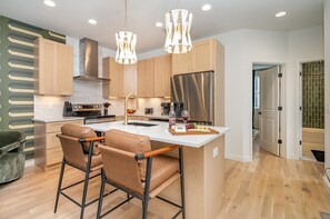 2nd Floor: Fully equipped kitchen with stainless steel appliances and a kitchen island with seating for 2 guests.