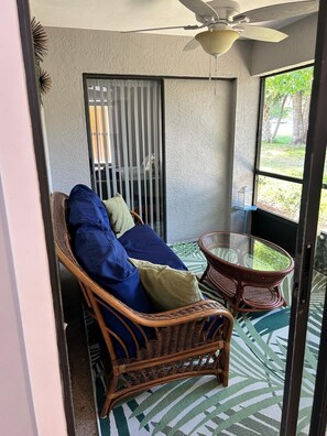 Cozy screened patio with a wicker sofa