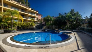 The complex features a shared pool with a tropical vibe, complete with a unique bridge connecting two oval-shaped pools. Exclusive to residents, it offers a serene, relaxing retreat within the complex. #pool #funchal