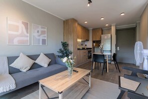 Cozy and modern open-plan living space with stylish decor and a fully equipped kitchen, perfect for relaxing and dining.