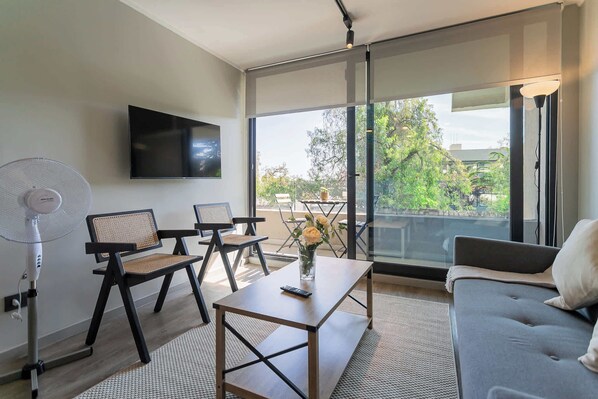 Relax in this stylish living room with natural light and a serene view, perfect for unwinding after a day of exploring.