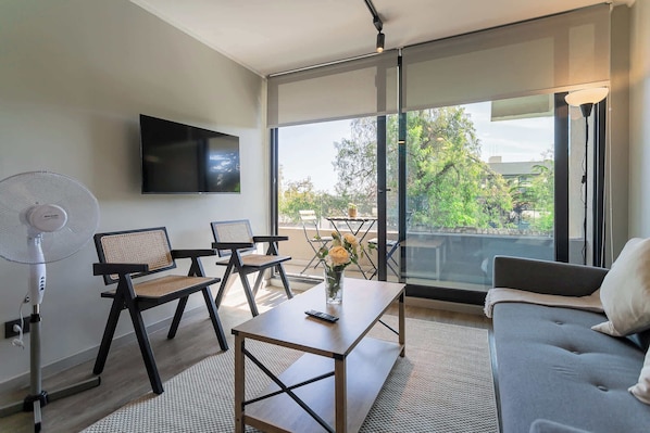 Relax in this stylish living room with natural light and a serene view, perfect for unwinding after a day of exploring.