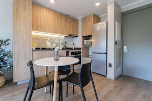 Experience a stylish kitchen with modern amenities, perfect for preparing meals during your stay. Enjoy the minimalist design and cozy dining area!