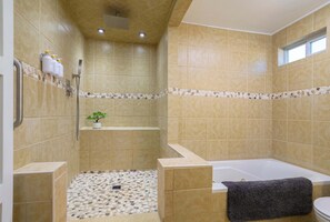 The primary ensuite bath features a chic vanity, shower, & jetted tub 