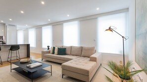 Bright, inviting living room with a plush sectional, chic decor, and large windows that let in ample natural light.
#CozyLivingRoom #NaturalLight #ModernComfort