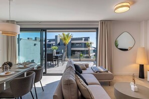 Spacious and inviting living room with a large sofa, TV, and dining area. Direct terrace access. (3)