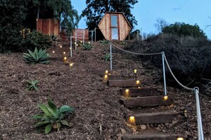 Steps lead to a secluded retreat featuring a private sauna, outdoor shower, and relaxing soaking tub