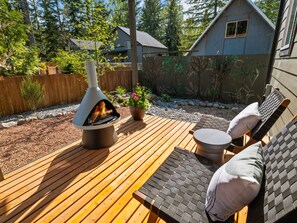 This covered deck features a stylish Solo fireplace and comfortable seating with plush pillows. 