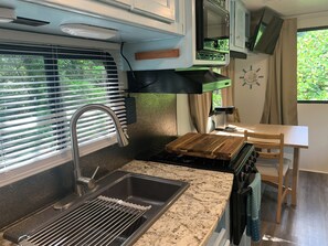 RV kitchenette with wood block prep area.